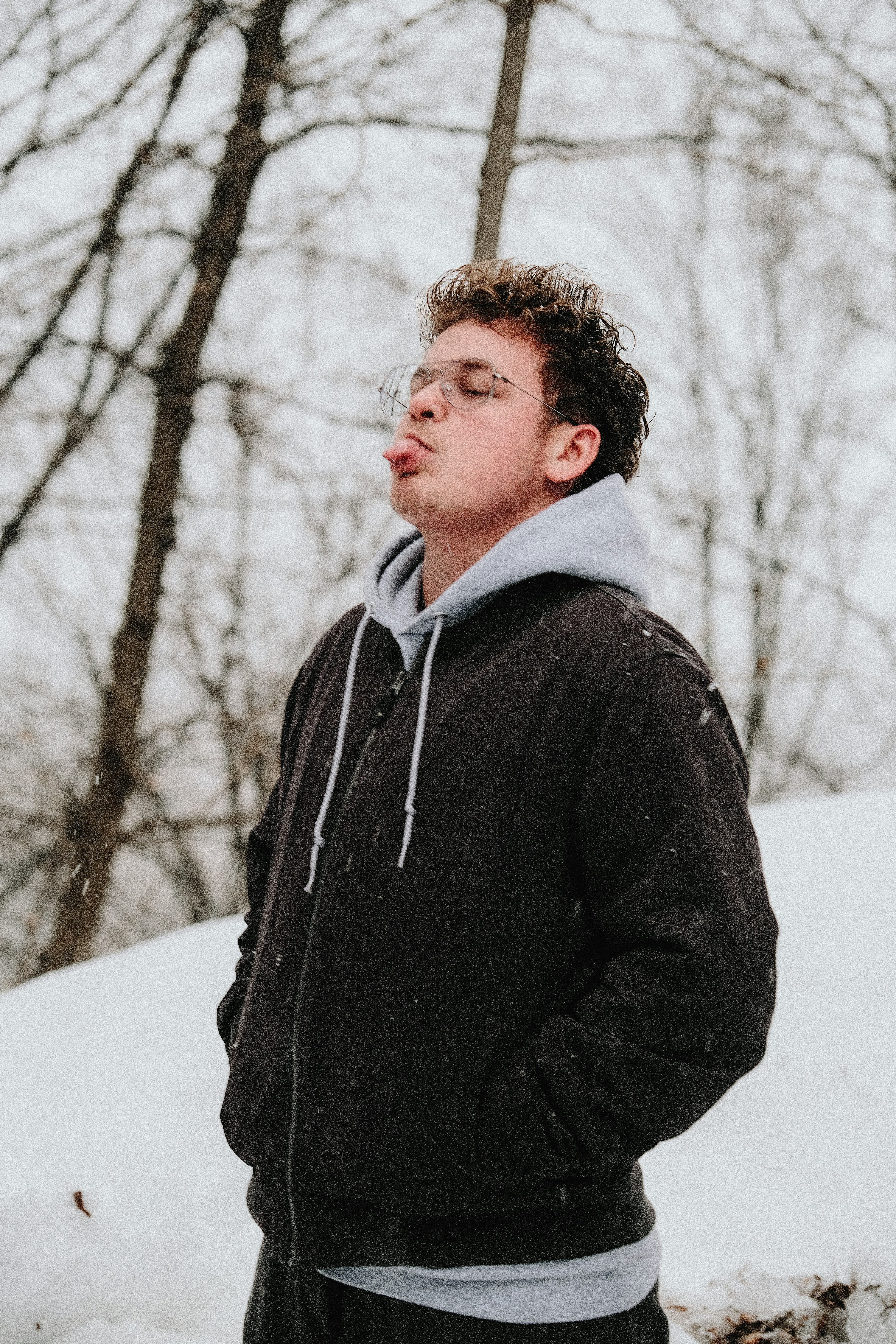 man in black jacket standing on snow covered ground during daytime