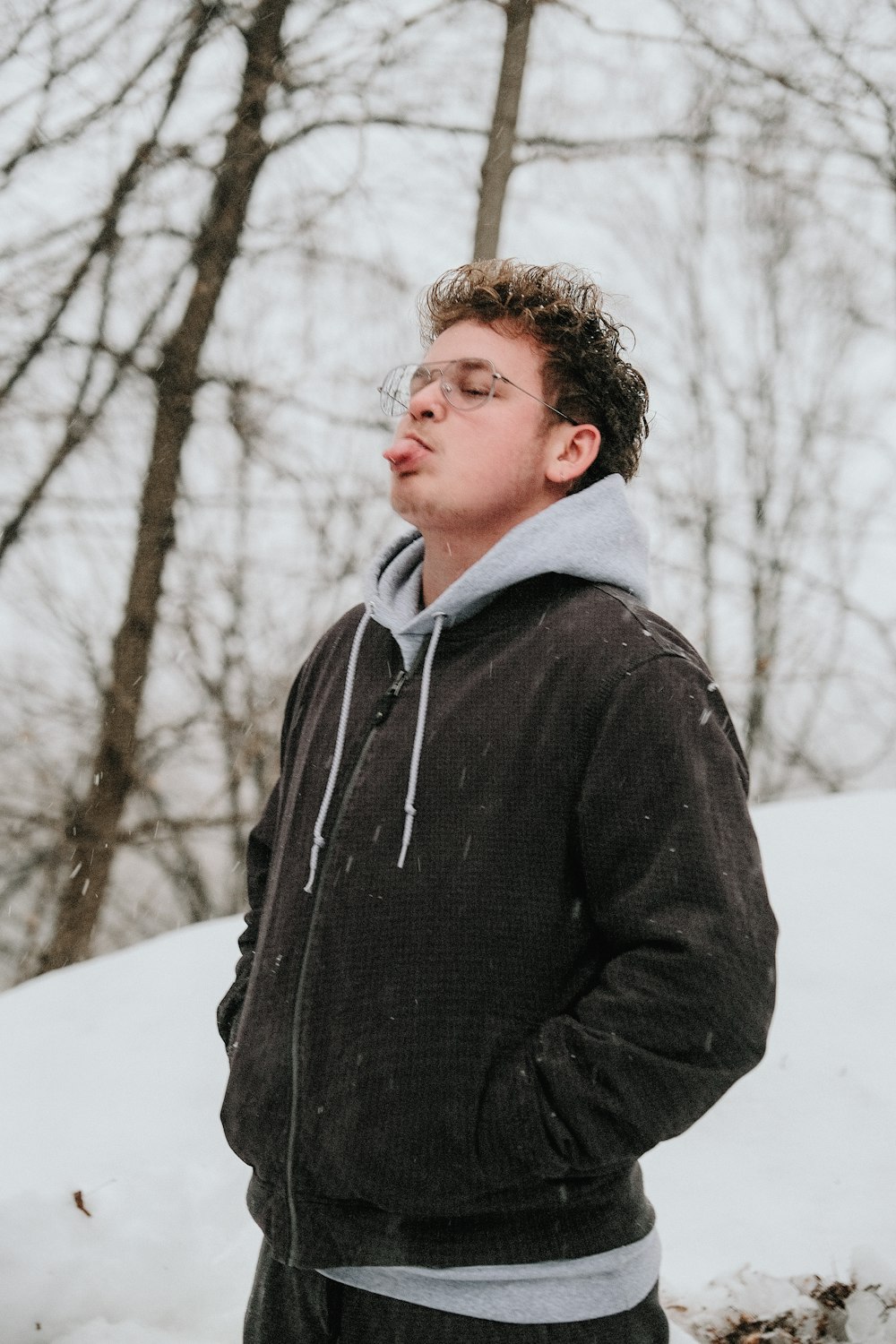 man in black jacket standing on snow covered ground during daytime