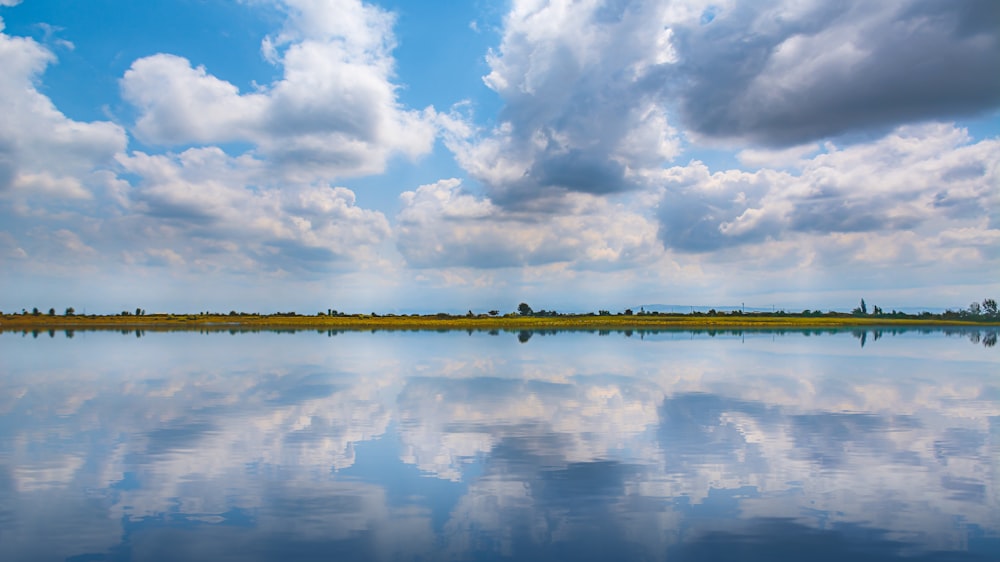 specchio d'acqua sotto il cielo nuvoloso durante il giorno