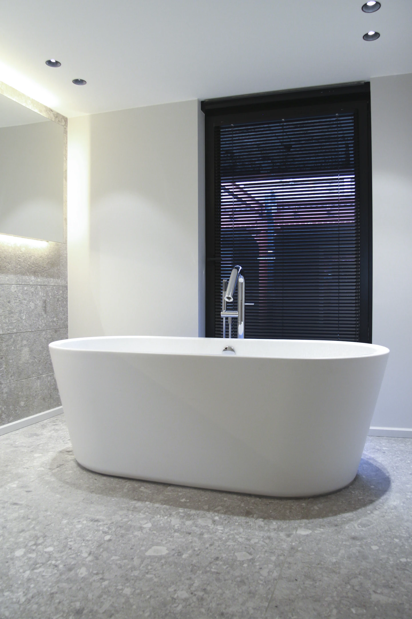 Freestanding bath beside a tall window