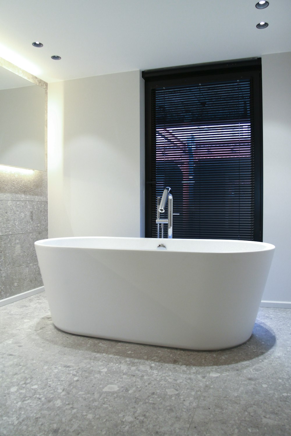 white ceramic bathtub near window