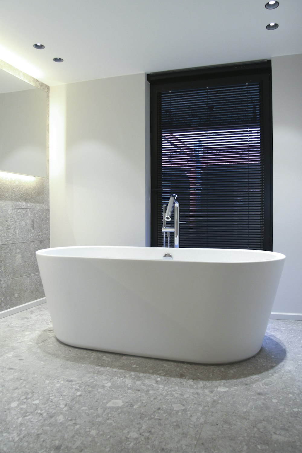 white ceramic bathtub near window