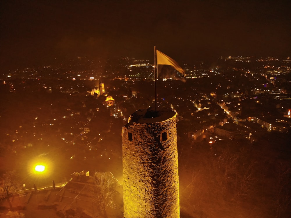 torre in cemento marrone con la bandiera di noi a durante la notte