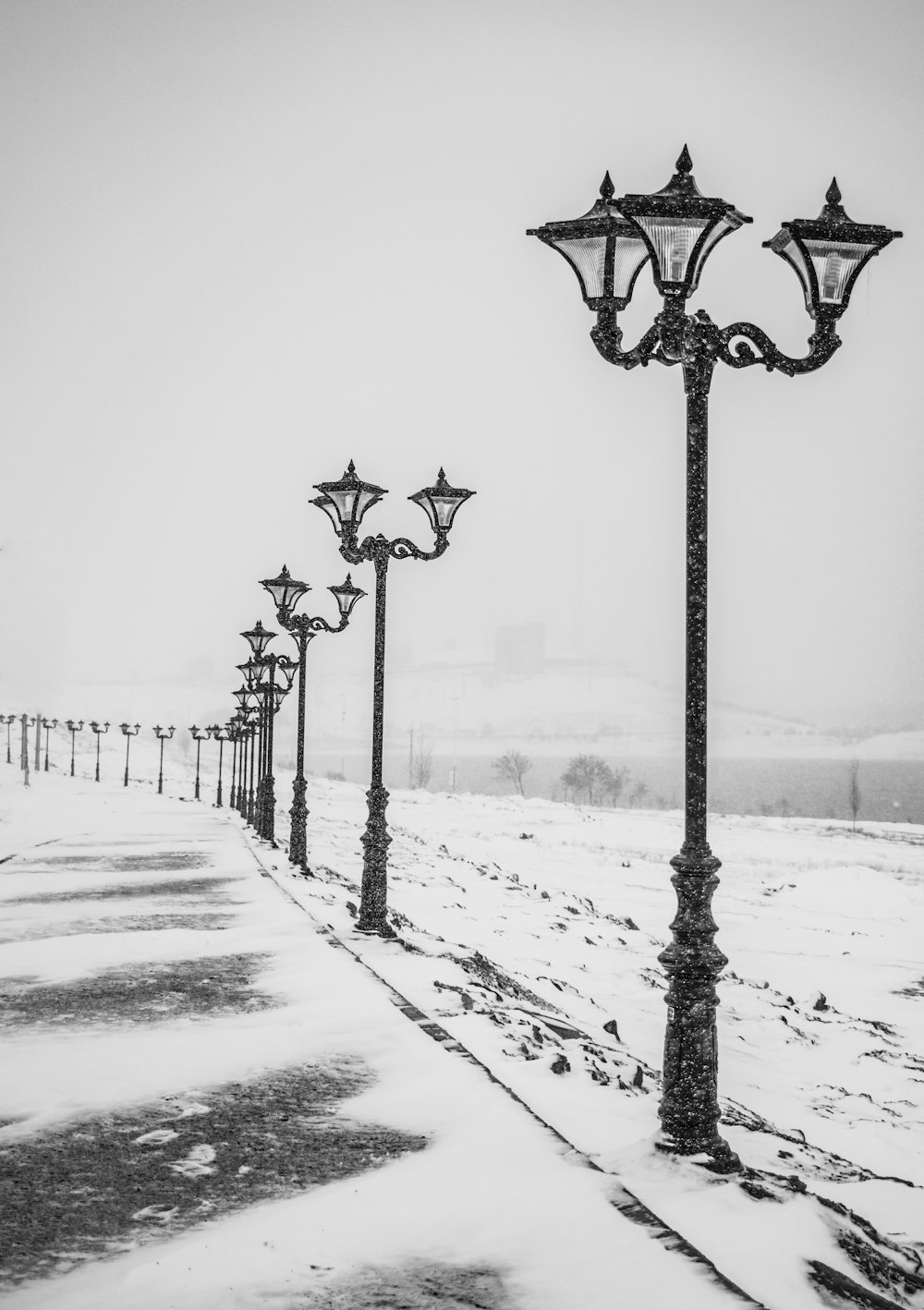 farola negra en suelo cubierto de nieve