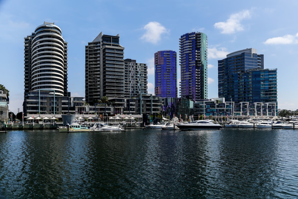 white and black boat on body of water near city buildings during daytime