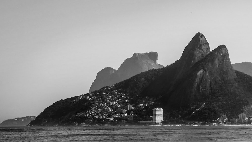 grayscale photo of mountain and body of water