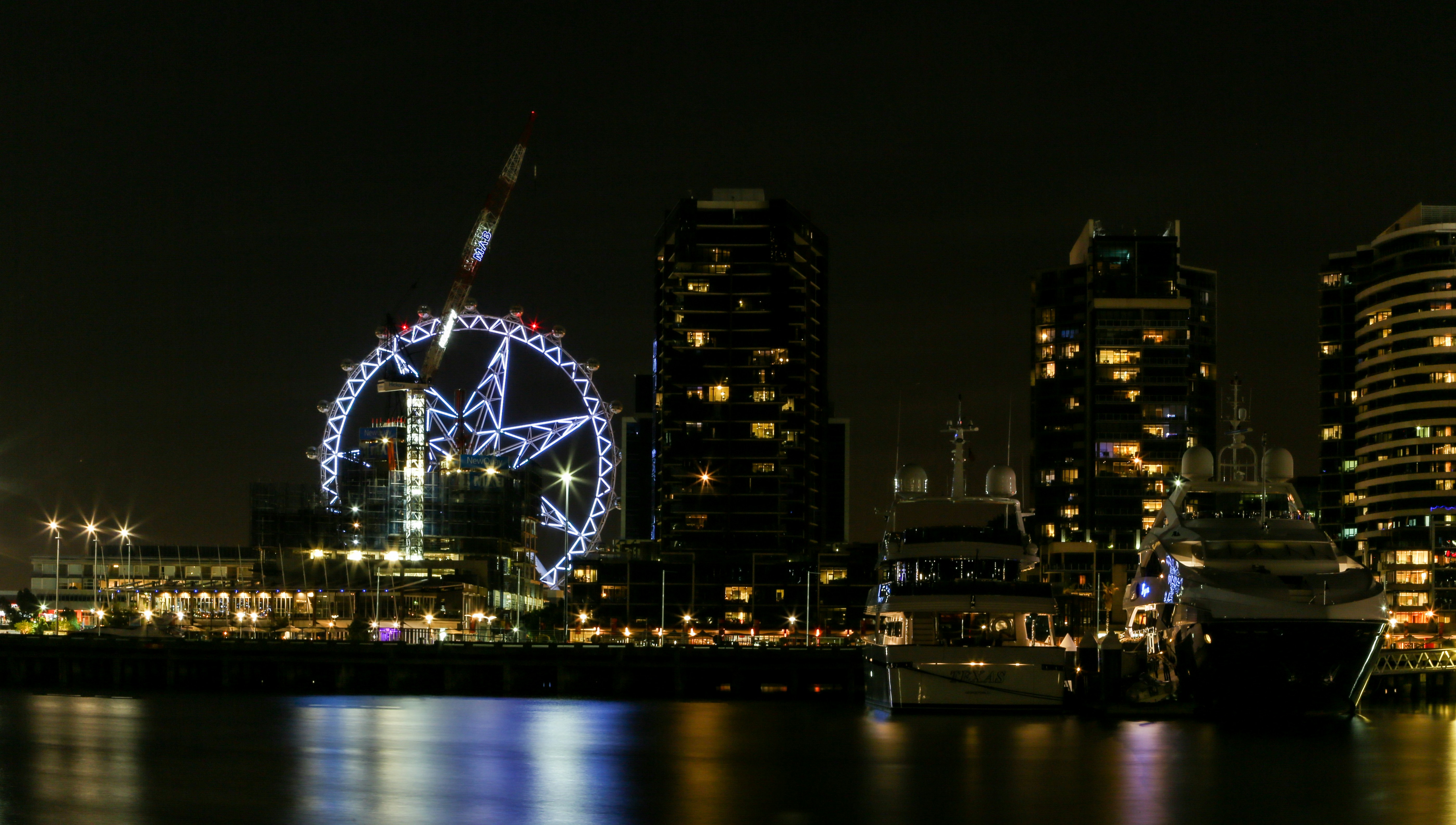 ferris wheel near city buildings during night time