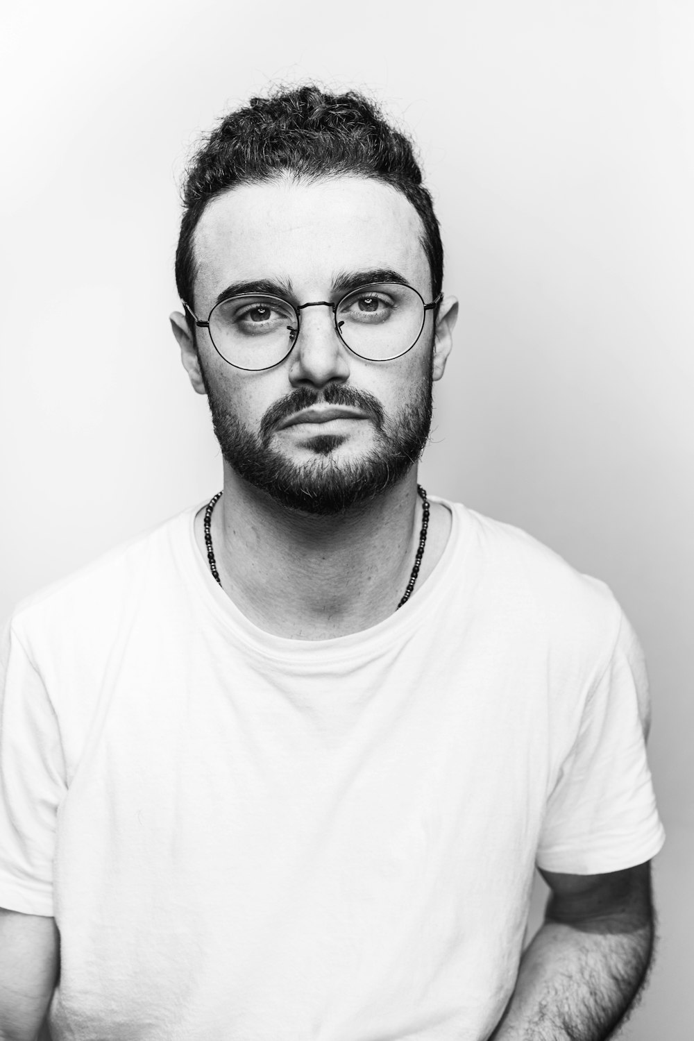 man in white crew neck shirt wearing black framed eyeglasses