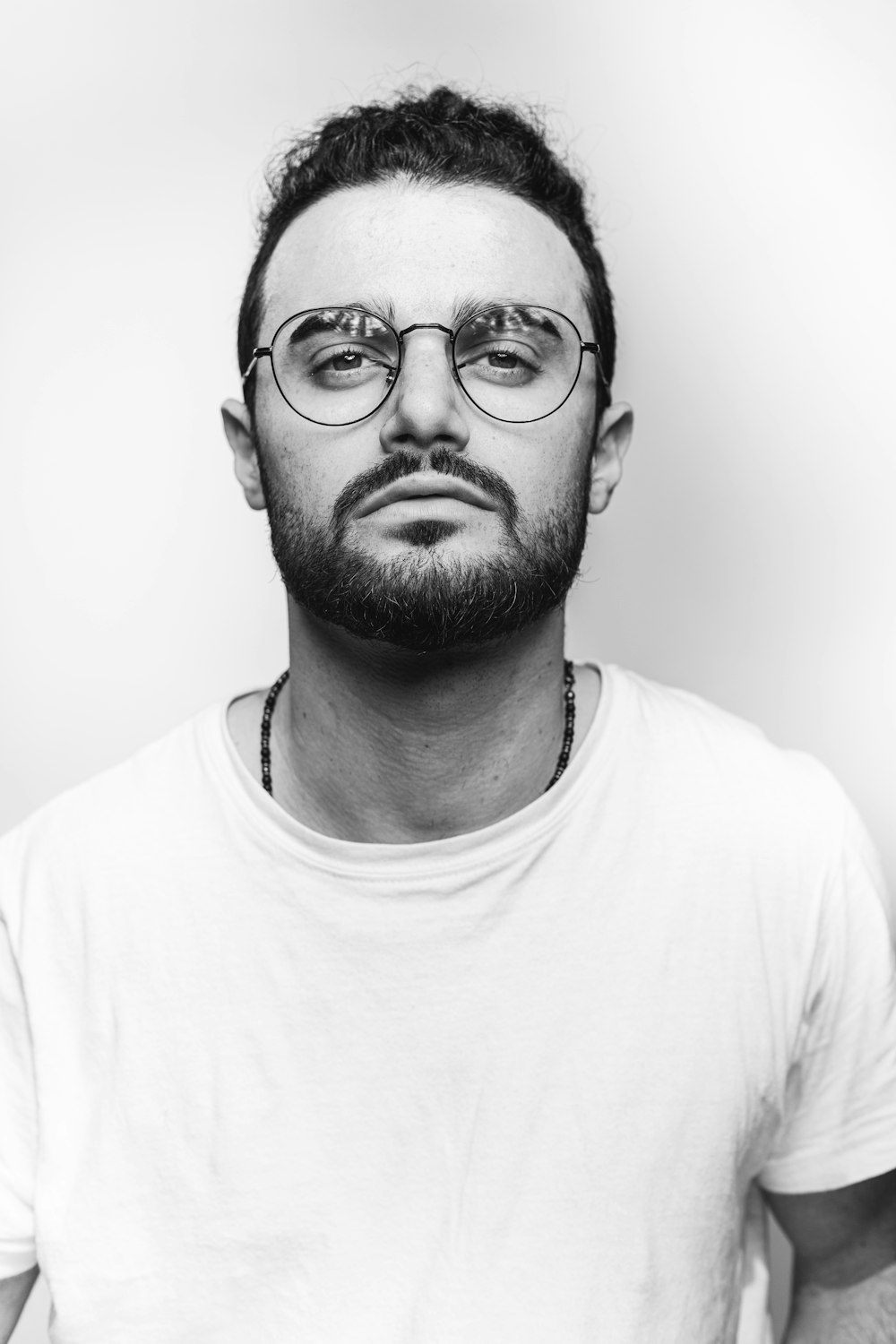 man in white crew neck shirt wearing black framed eyeglasses