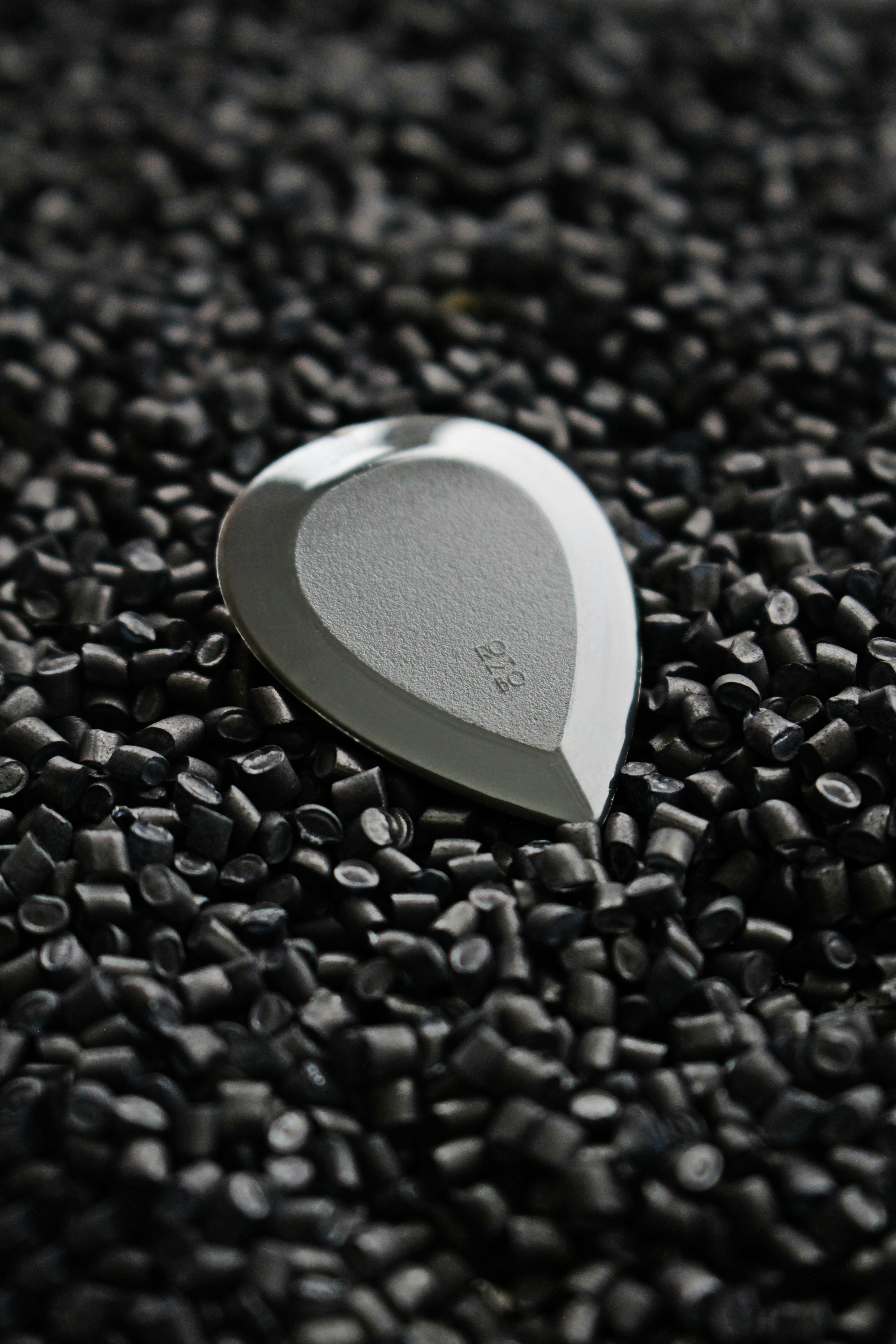 silver round frame on black and white pebbles