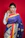 A joyful woman in a vibrant saree smiling confidently against a soft, elegant background.