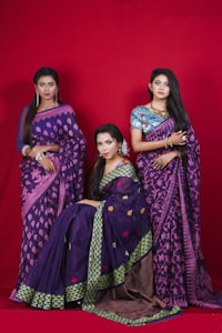 Three women in purple and pink sarees