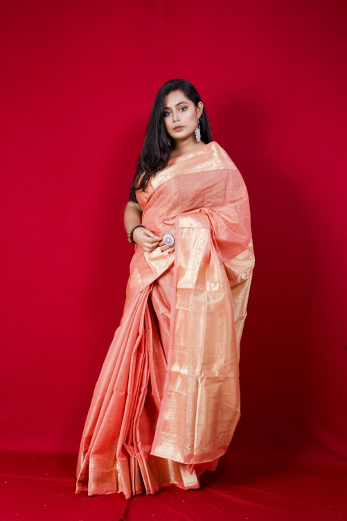 woman in pink and beige sari standing