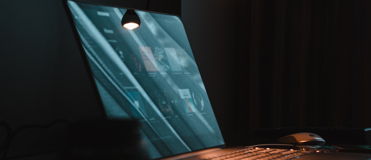 silver macbook on brown wooden table