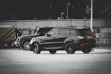 Sleek dark SUV with freshly tinted windows parked in an urban setting at sunset