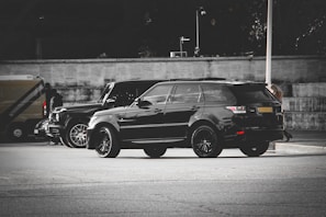 A sleek black suburban parked in an urban setting.