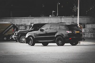 Black SUV parked in urban setting with deep, uniform tint highlighting OEM-grade quality.