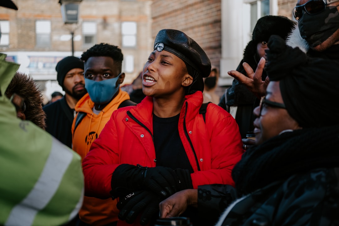 man in red and black jacket wearing blue cap