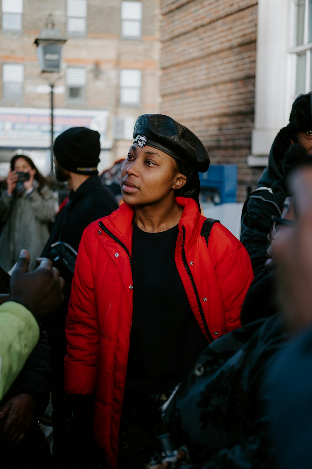 man in red jacket wearing black knit cap