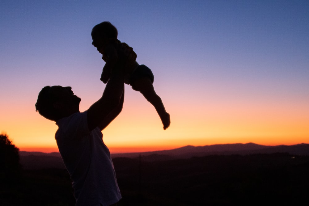 Silhouette von Mann und Frau, die sich während des Sonnenuntergangs küssen