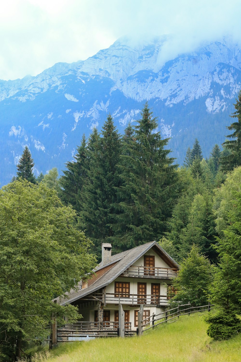 Casa de madera marrón cerca de árboles verdes y montaña durante el día