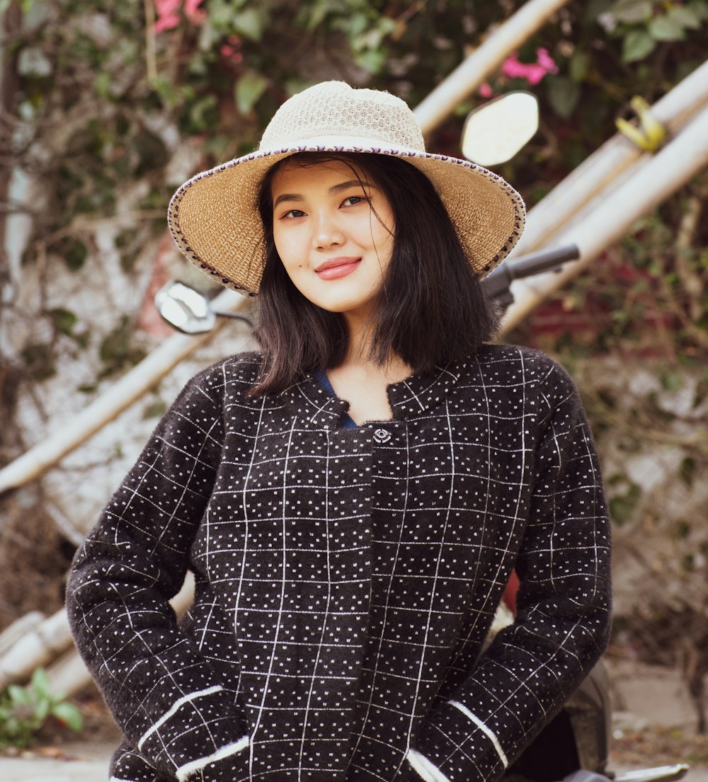 woman in black and white long sleeve shirt wearing brown straw hat