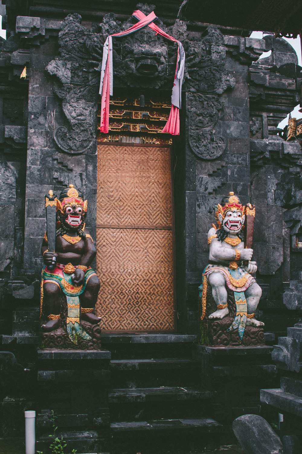 3 brown and red wooden figurines