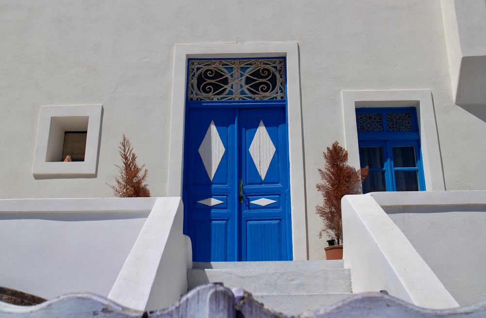 blue wooden door on white concrete building