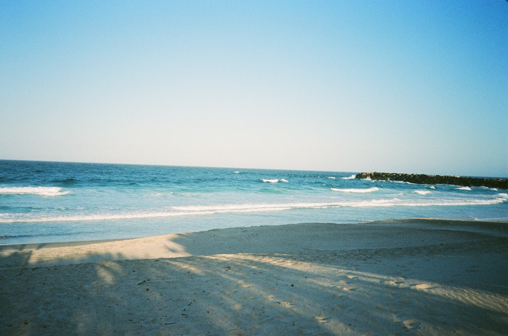 sea waves crashing on shore during daytime