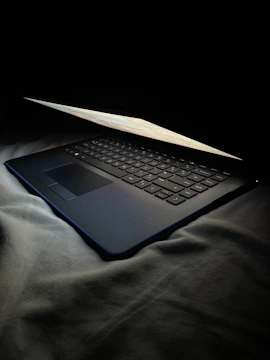Open laptop on a dark desk with a tech blog open on screen.