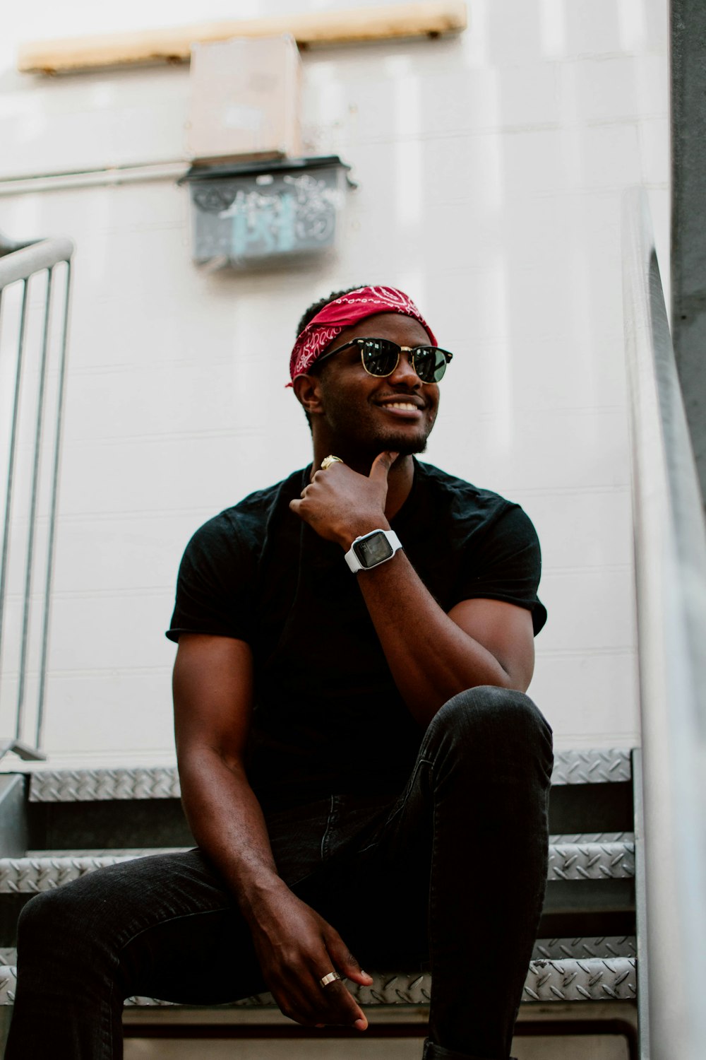 man in black crew neck t-shirt and black pants sitting on white concrete stairs