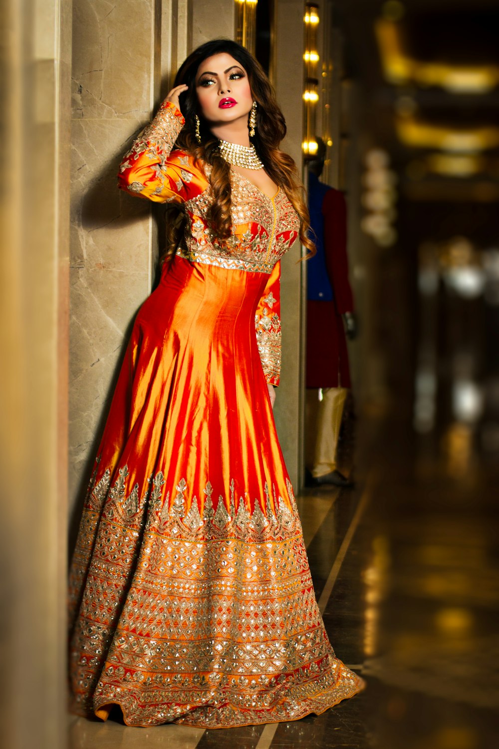 woman in red and brown dress standing on brown wooden floor