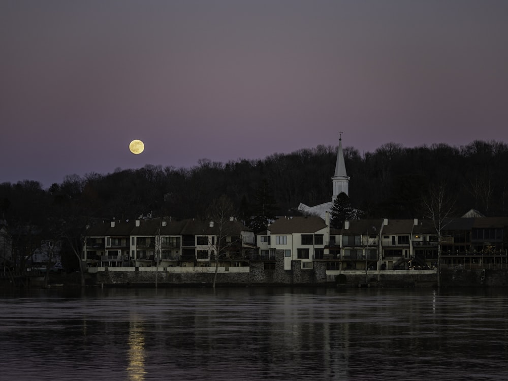 white and brown house near body of water during sunset