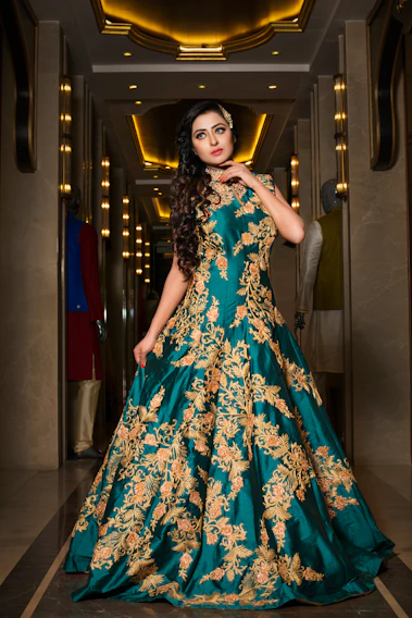 Ania J in a flowing gold gown under shimmering chandeliers at a midnight gala.