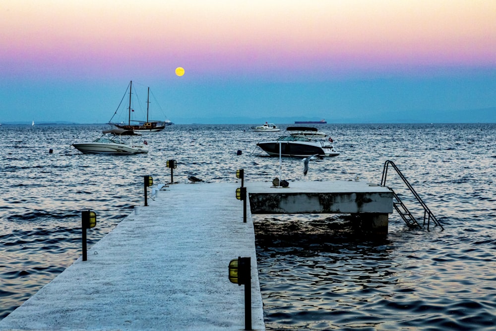 white yacht on sea dock during sunset