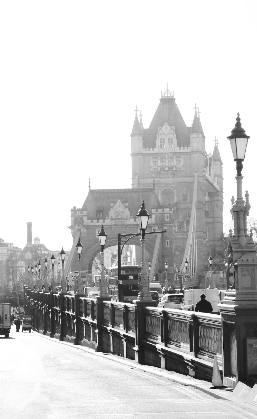 grayscale photo of people walking on bridge