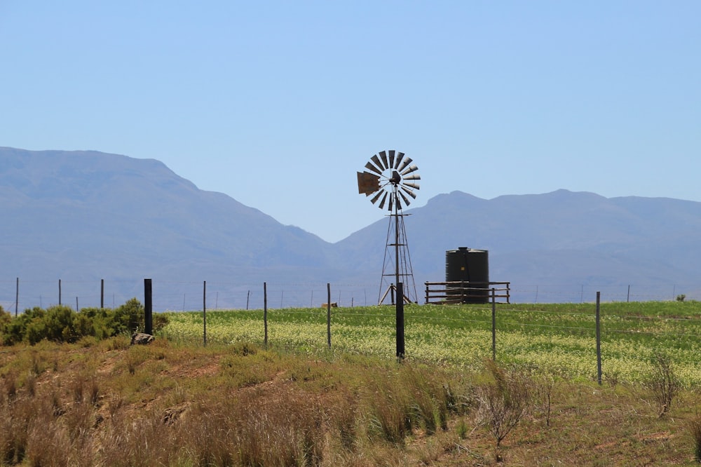 black and white windmill on green grass field during daytime