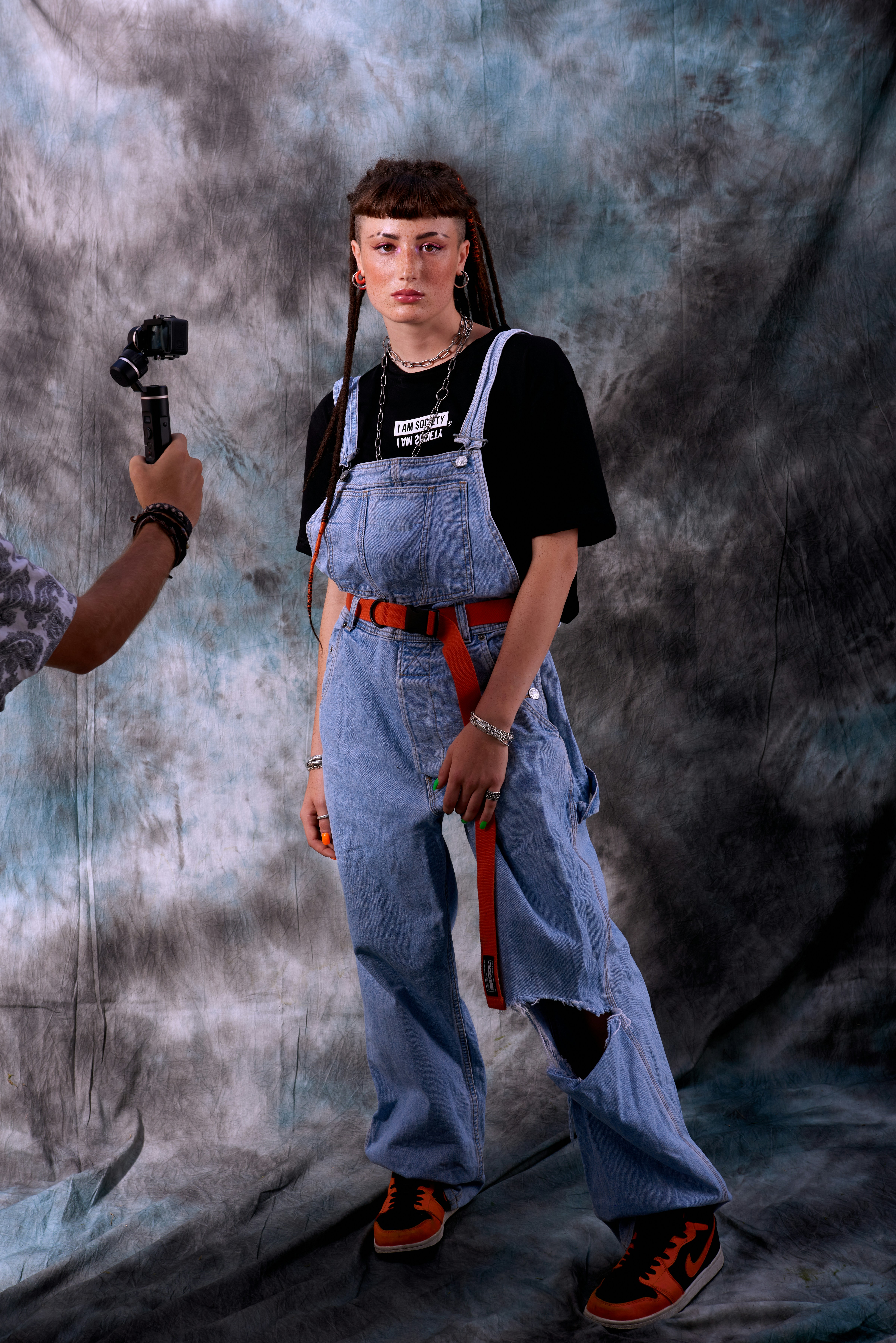 woman in black and white crew neck t-shirt and orange skirt holding black camera