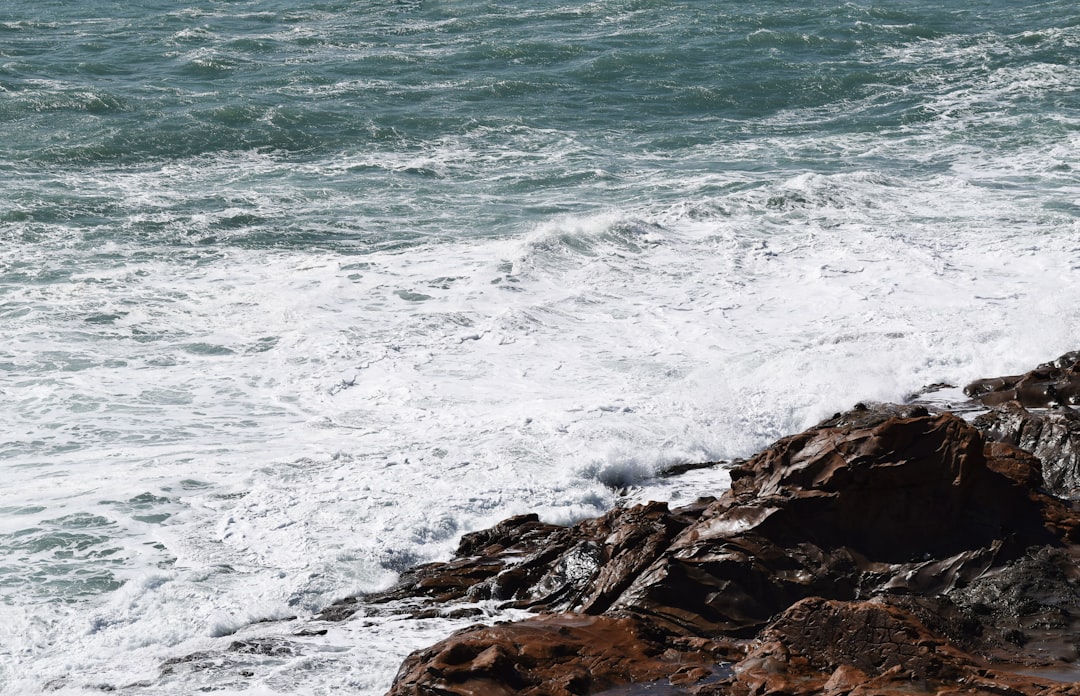 ocean waves crashing on rocky shore during daytime