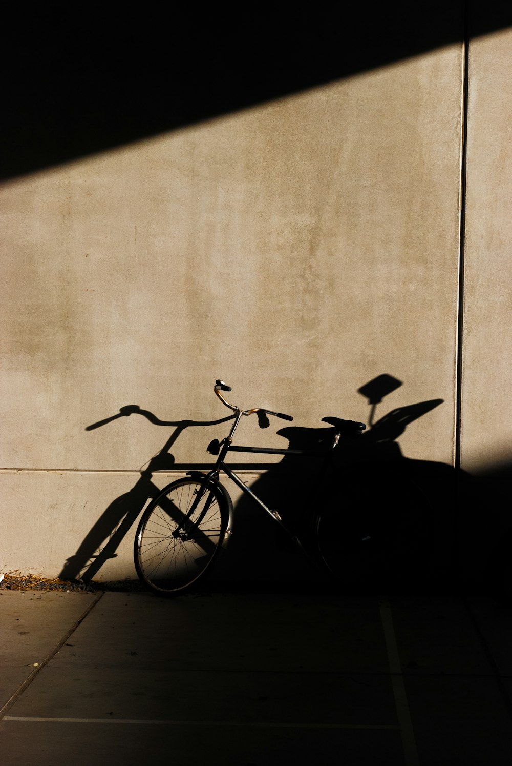black bicycle leaning on wall