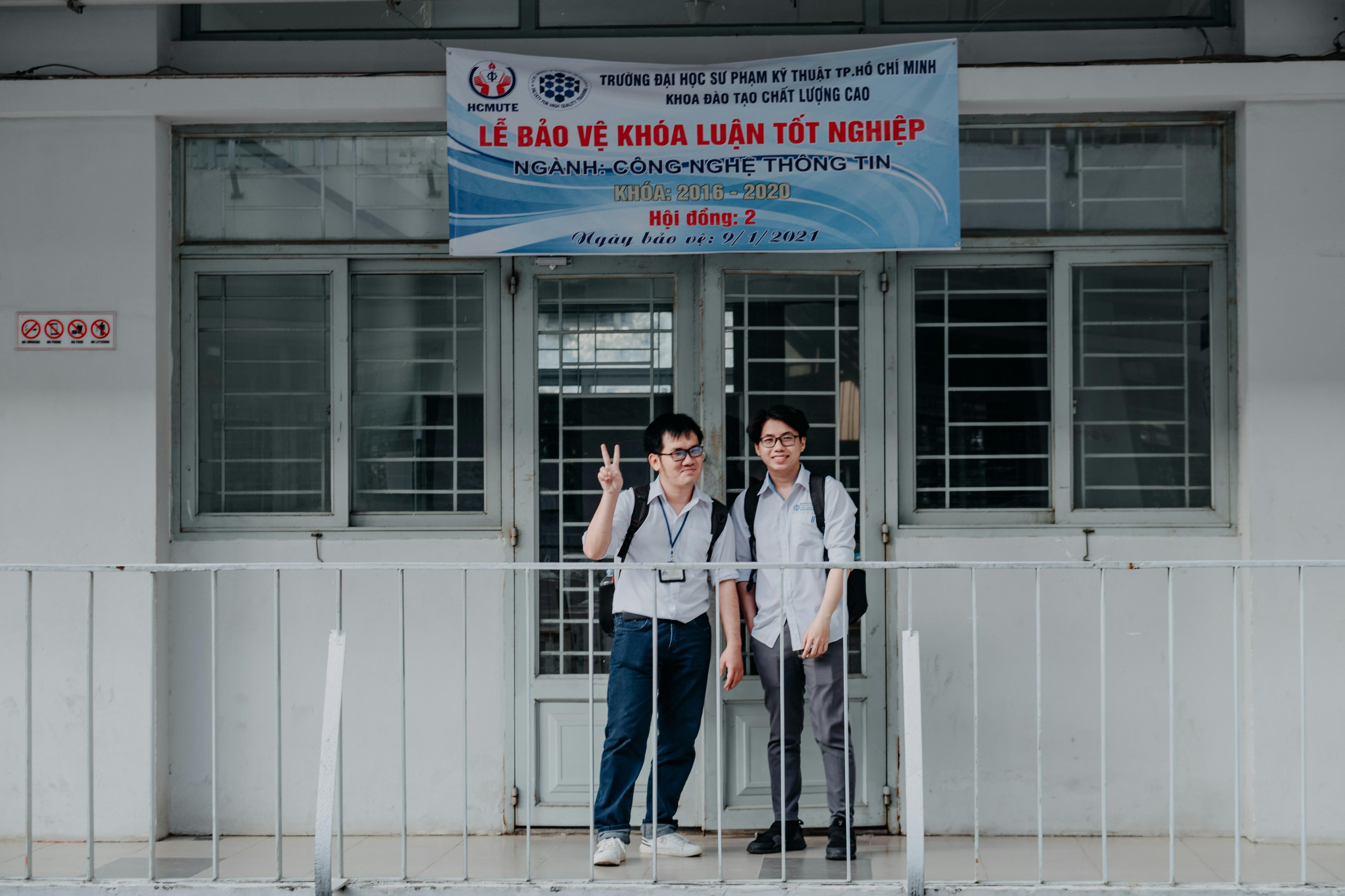 man and woman standing beside white building