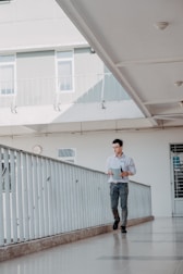 A technician inspecting a communal hallway with a clipboard in hand.