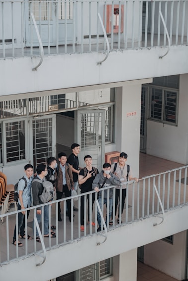 A group of diverse university students happily interacting in a modern dorm common area.