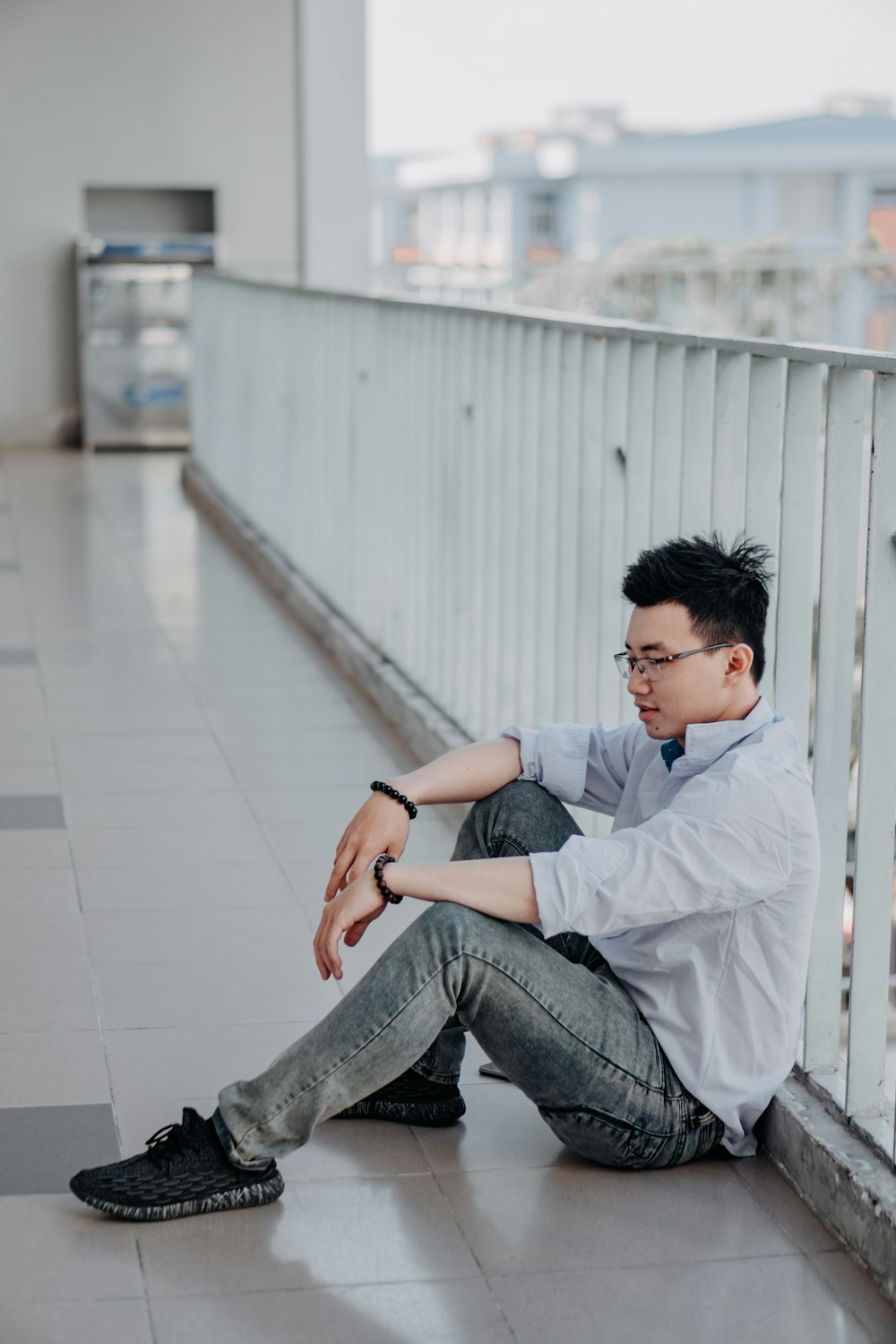 Foto Hombre con camisa de vestir blanca y jeans de mezclilla gris sentado  en el piso de concreto blanco durante el día – Imagen Gris gratis en  Unsplash