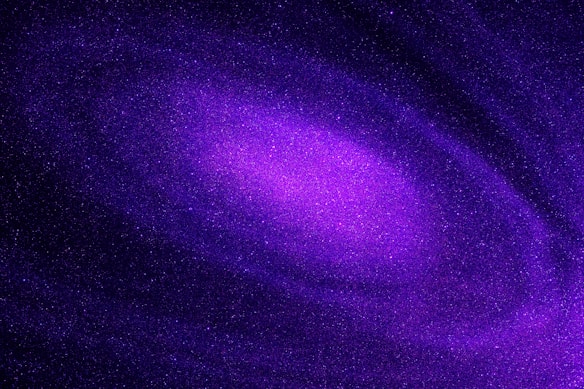 A vibrant, swirling galaxy filled with countless stars, predominantly in shades of purple and violet. Cosmic dust and nebulae create a mesmerizing celestial pattern.