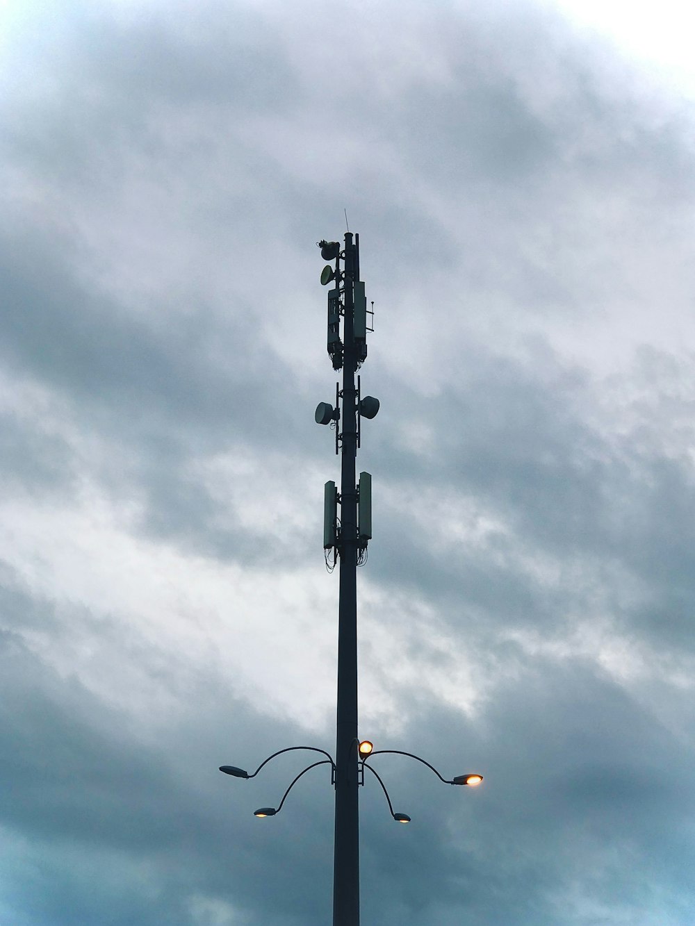 black street light under gray clouds