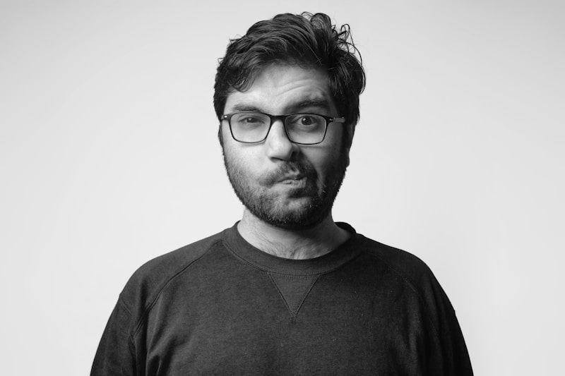 man in black crew neck shirt wearing black framed eyeglasses