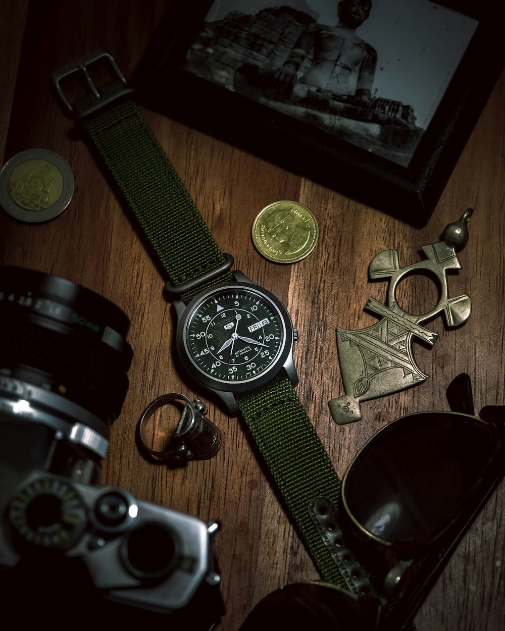 black round analog watch with black leather strap beside silver round analog watch