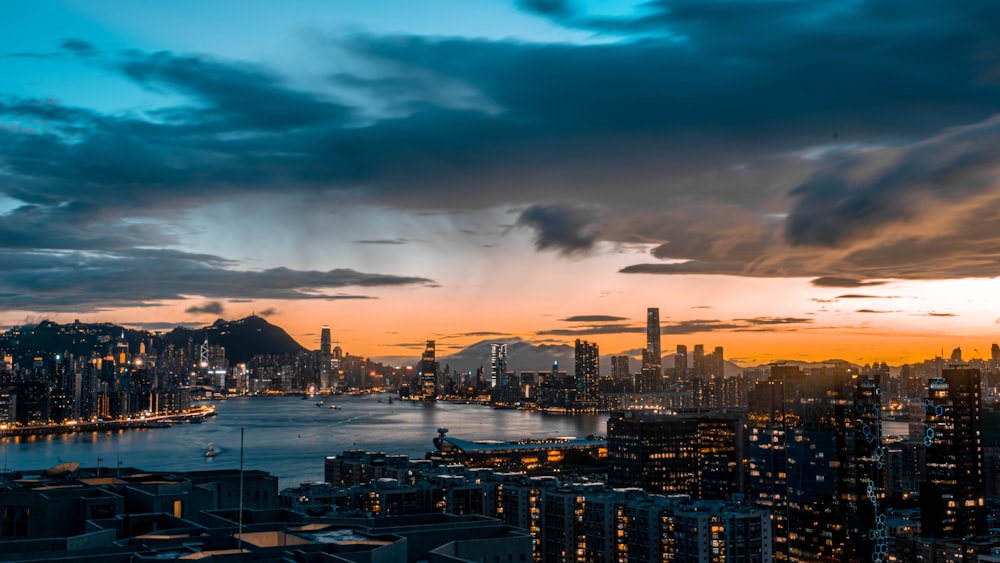 city skyline under cloudy sky during night time