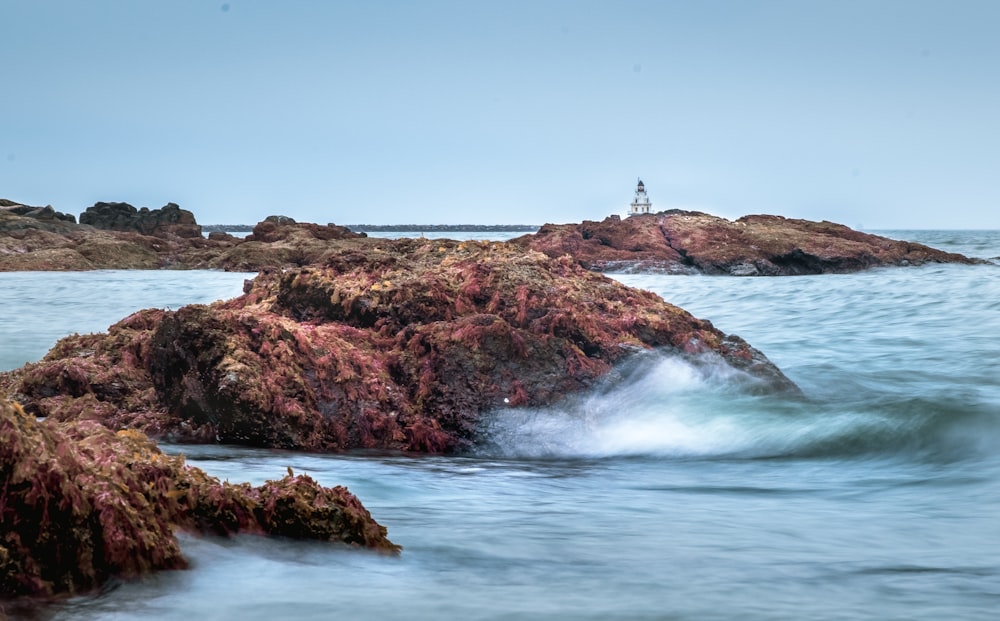 brown rock formation on sea water during daytime